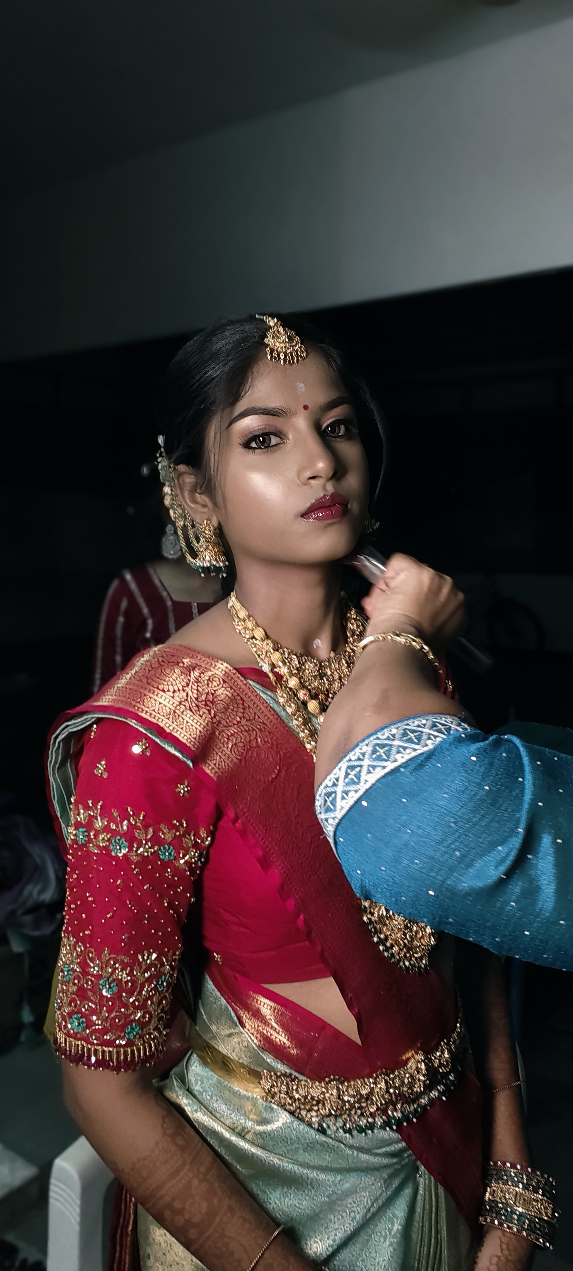 Bride receiving finishing touches before the ceremony