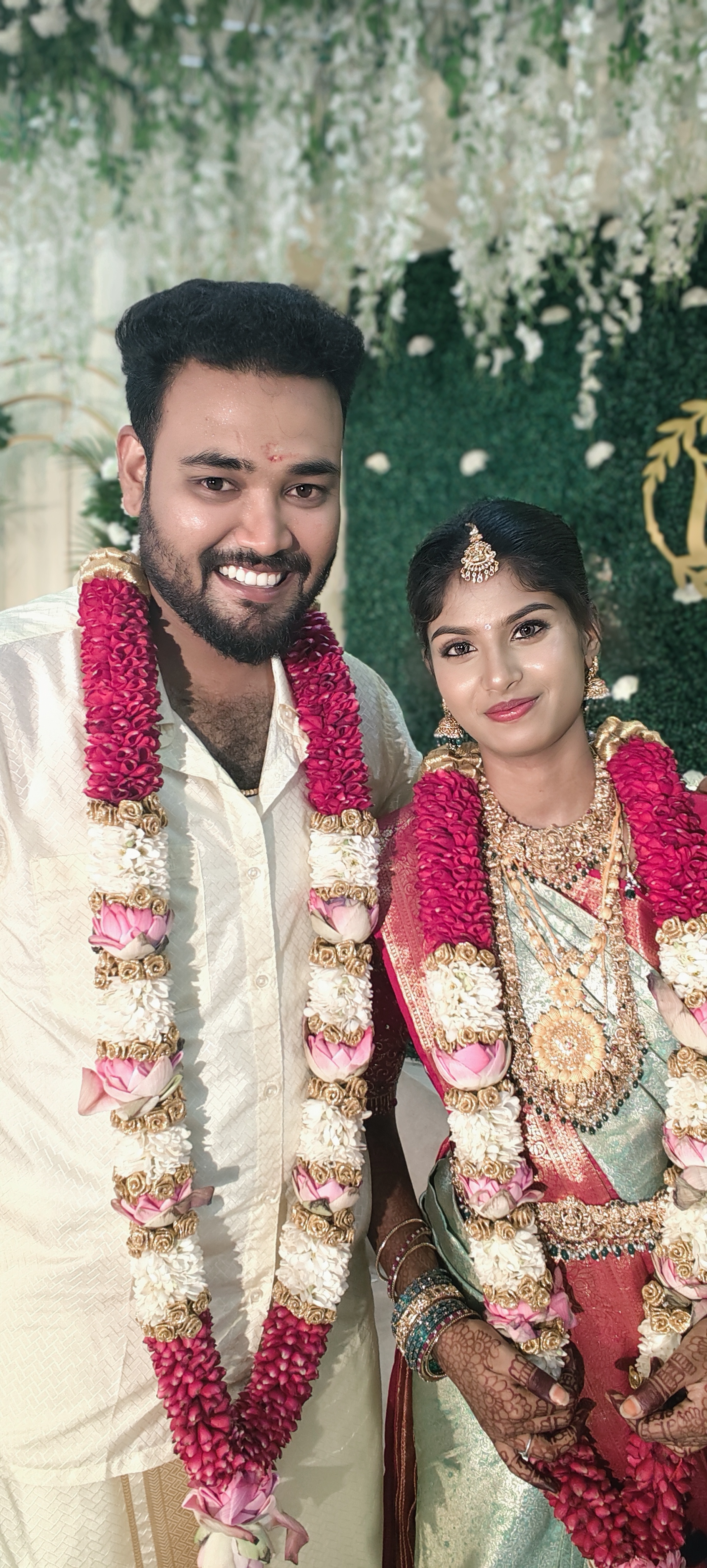 Couple on wedding day with garlands